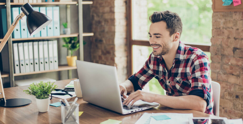 smiling man working on laptop